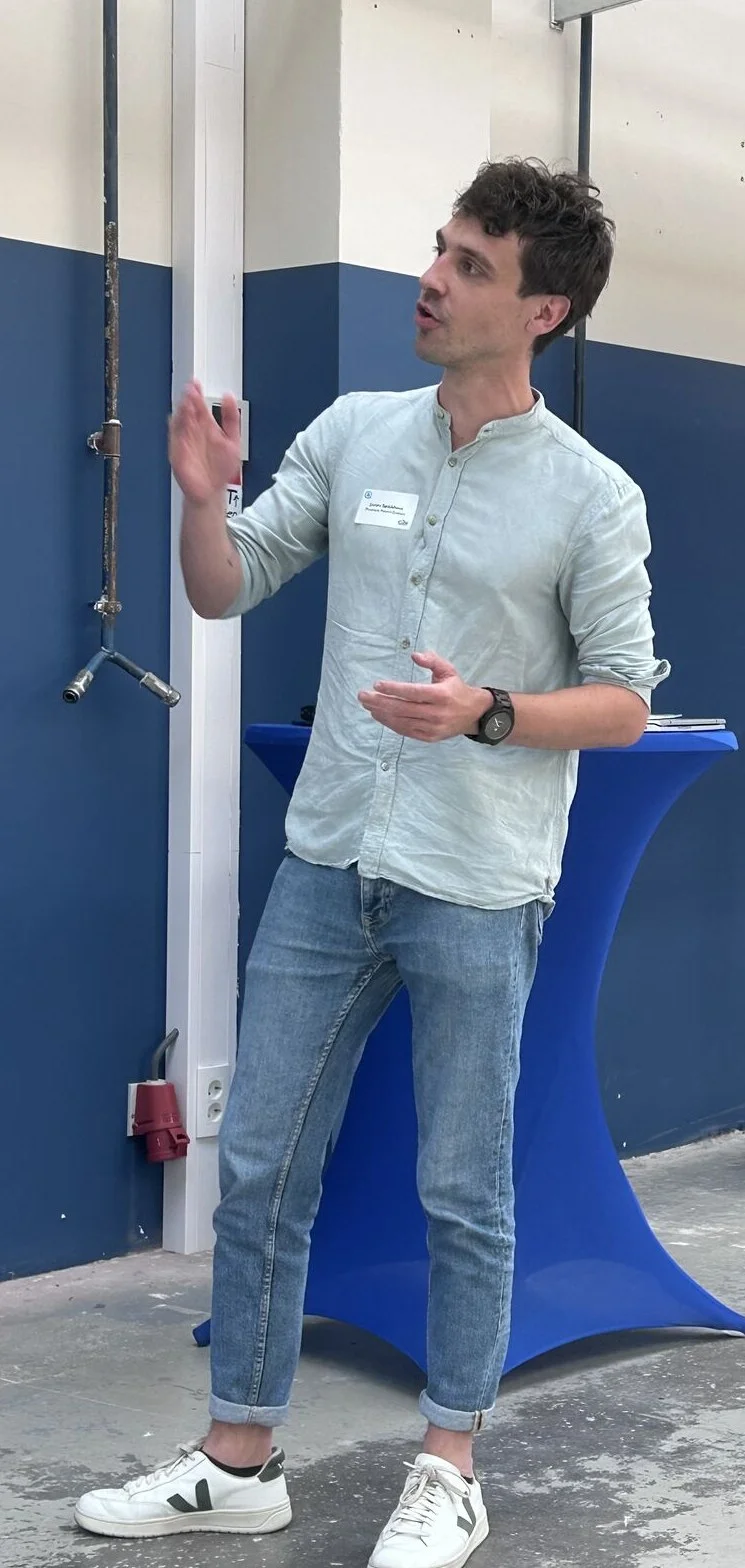 Jorim geeft een presentatie naast een scherm met dia's